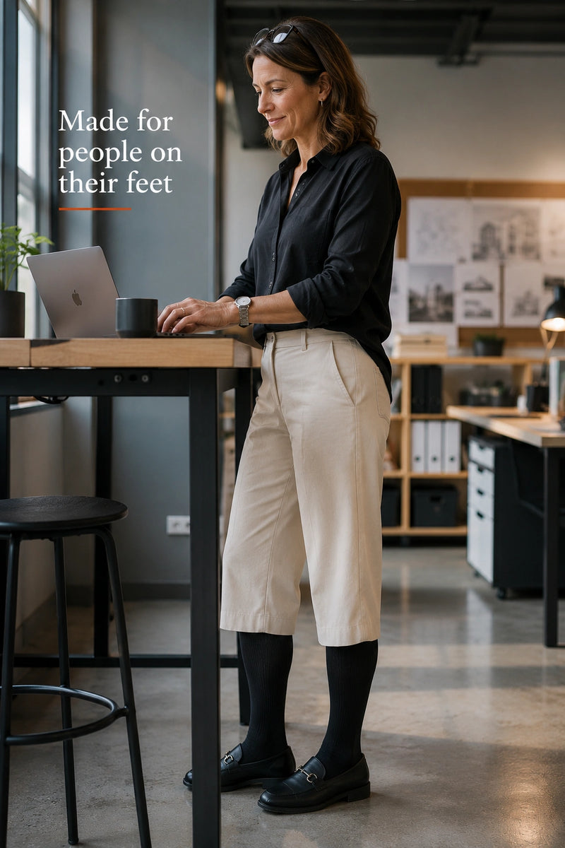 Woman wearing The Well Socks knee-high compression socks at a standing desk graduated compression socks 15-25 mmHg