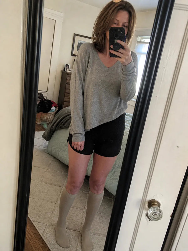 Woman relaxing indoors in dark blue compression socks