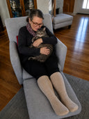 Woman putting on The Well Socks compression socks at home — super-stretch easy fit